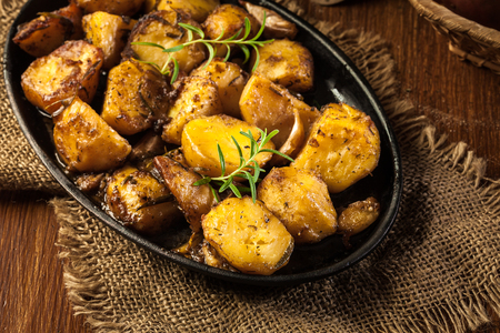 Roasted potatoes with garlic and rosemary on baking dishの写真素材
