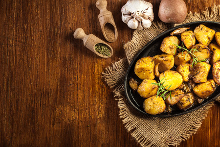 Roasted potatoes with garlic and rosemary on baking dishの写真素材