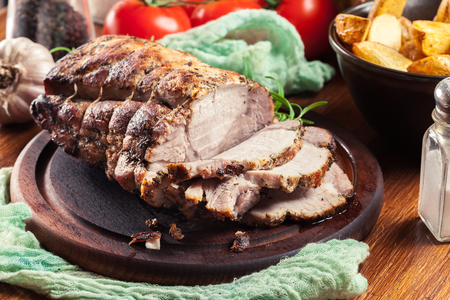 Roasted pork loin with herbs on cutting boardの写真素材