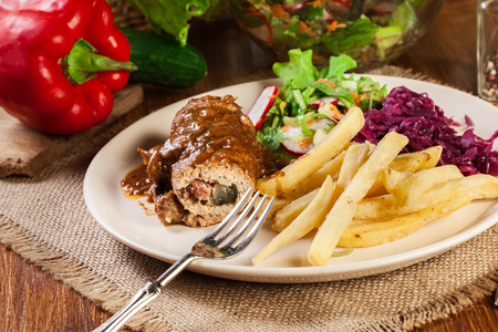 Pork roulade with french fries with salad on a plateの写真素材