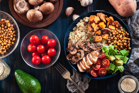 Vegetable buddha bowl lunch with chicken and quinoa, chickpea, mushrooms, lettuce and tomatoes. Healthy food conceptの写真素材