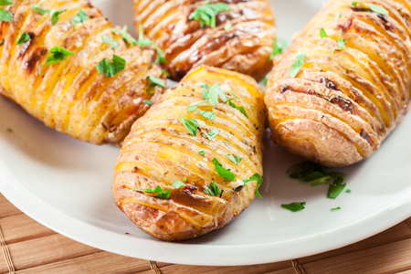 Hasselback potatoes. Baked potatoes with cheese and herbs. Swedish cuisineの写真素材