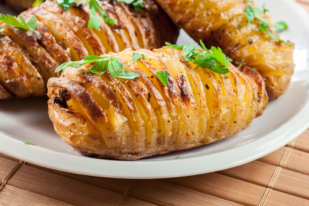 Hasselback potatoes. Baked potatoes with cheese and herbs. Swedish cuisineの写真素材