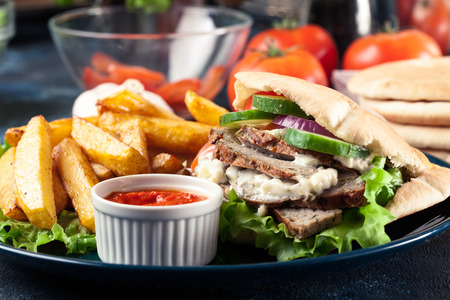 Doner kebab - fried minced meat in pita bread with french fries and ajvarの写真素材