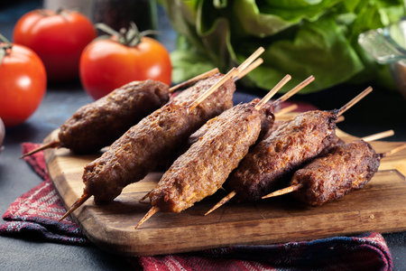 Grilled balkan cevapcici or shish kebab on skewers served on cutting boardの写真素材