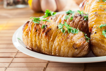 Hasselback potatoes. Baked potatoes with cheese and herbs. Swedish cuisineの写真素材