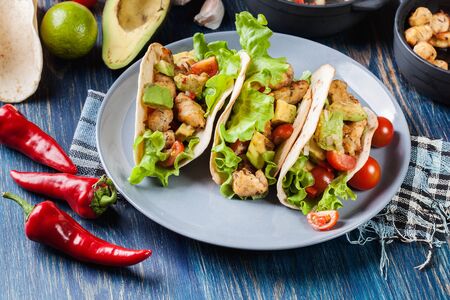 Authentic mexican tacos with chicken and salsa with avocado, tomatoes and chillies. Mexican cuisine.の写真素材