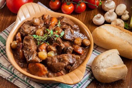 Beef Bourguignon stew served with baguette on dish. French cuisineの写真素材