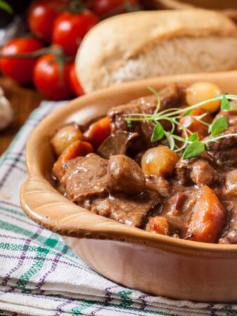 Beef Bourguignon stew served with baguette on dish. French cuisineの写真素材