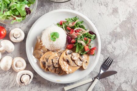 Chicken escalopes with champignion in creamy sauce served with riceの写真素材
