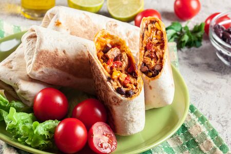 Burritos wraps with mincemeat, beans and vegetables. Mexican dishの写真素材