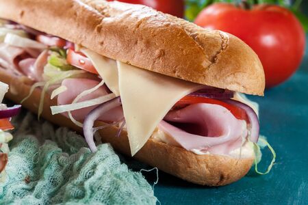 Submarine sandwiches with ham, cheese, tomatoes, cabbage and cucumber. Fresh delicious dishの写真素材