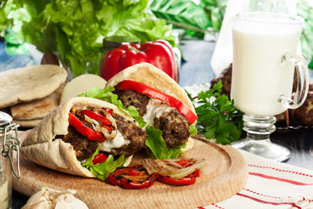 Tasty kofta kebab with grilled paprika and onion served on pita flatbreadの写真素材