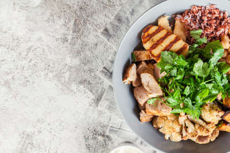 Buddha bowl lunch with chicken and red rice, chickpea, cauliflower and Halloumi cheese. Healthy food conceptの写真素材