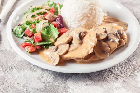 Chicken escalopes with champignion in creamy sauce served with riceの写真素材