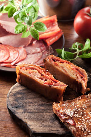Italian stromboli stuffed with ham, salami, cheese and vegetablesの写真素材