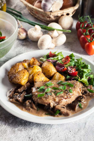 Pork loin chop with mushroom sauce and baked potatoes. Delicious dishの写真素材