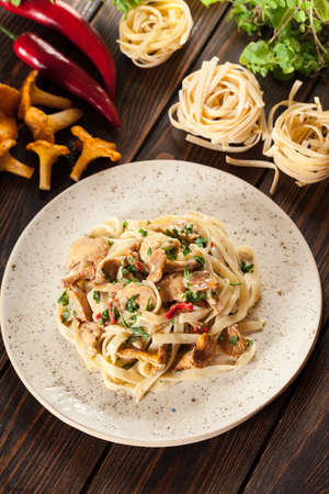 Tagliatelle pasta with chicken and chanterelles mushrooms with creamy sauceの写真素材