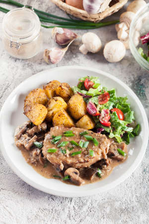 Pork loin chop with mushroom sauce and baked potatoes. Delicious dishの写真素材