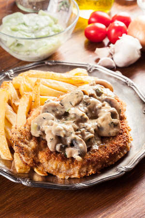 Traditional hunter schnitzel with a mushroom gravy and french fries. German cuisineの写真素材