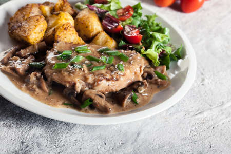 Pork loin chop with mushroom sauce and baked potatoes. Delicious dishの写真素材