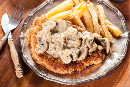 Traditional hunter schnitzel with a mushroom gravy and french fries. German cuisineの写真素材