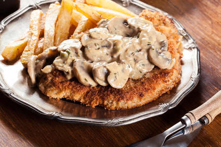 Traditional hunter schnitzel with a mushroom gravy and french fries. German cuisineの写真素材