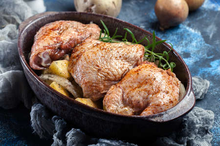 Chicken thighs and potatoes ready for baking in casserole dishの写真素材