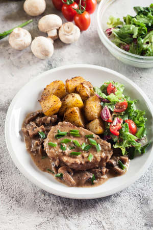 Pork loin chop with mushroom sauce and baked potatoes. Delicious dishの写真素材