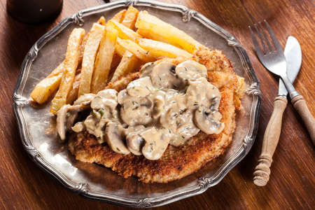 Traditional hunter schnitzel with a mushroom gravy and french fries. German cuisineの写真素材