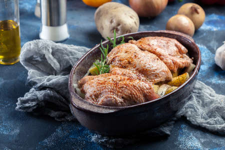 Chicken thighs and potatoes ready for baking in casserole dishの写真素材