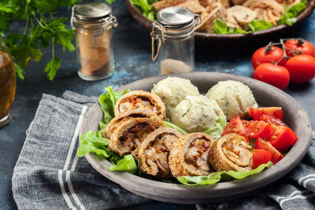 Pork rolls stuffed with mozzarella and sun-dried tomatoes served with mashed potatoes and saladの写真素材