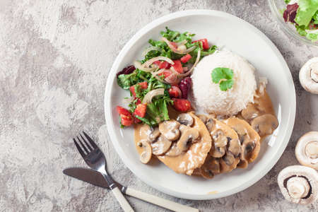 Chicken escalopes with champignion in creamy sauce served with riceの写真素材