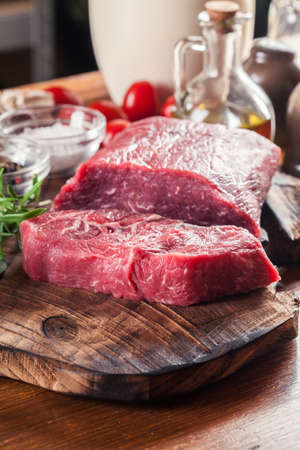 Raw beef steak on a cutting board. Making steak for grillingの写真素材