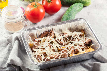 Making Kapsalon, Dutch fast food witch french fries, chicken tomatoes and cucumberの写真素材