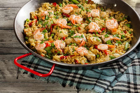 Traditional seafood paella with shrimp, fish and chicken seved in paellera. Spanish cuisineの写真素材