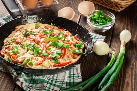 Fresh omelette with bacon and bell pepper on a panの写真素材