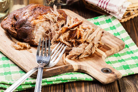 Slow cooked pulled pork shoulder on chopping board.の写真素材