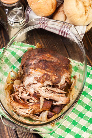 Slow cooked pulled pork shoulder with onion and garlic in casserole dishの写真素材