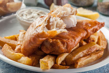 Traditional fish in beer batter and chips with green pea and tartar sauceの写真素材
