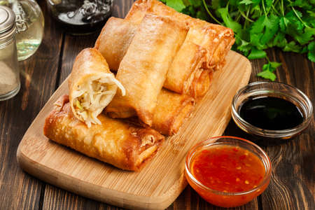 Spring rolls with chicken and vegetables on chopping board. Asian cuisine.の写真素材