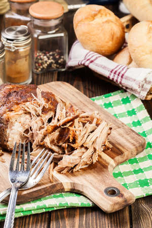 Slow cooked pulled pork shoulder on chopping board.の写真素材