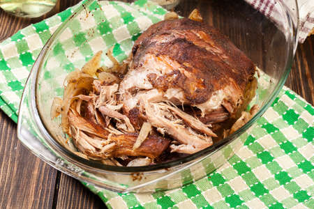 Slow cooked pulled pork shoulder with onion and garlic in casserole dishの写真素材