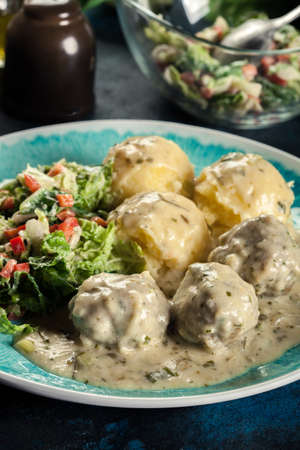 Meatballs with creamy and cheese gravy served with mashed potatoes balls and saladの写真素材