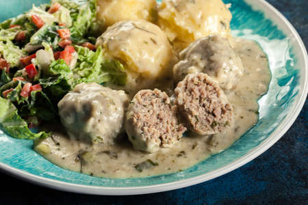 Meatballs with creamy and cheese gravy served with mashed potatoes balls and saladの写真素材