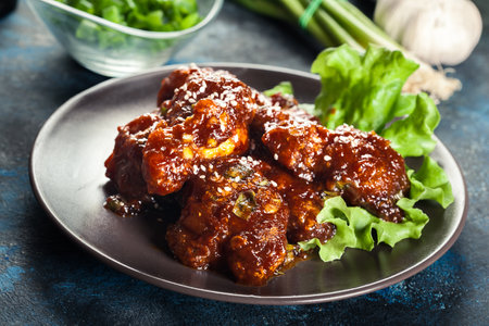 Sweet and spicy chicken wings on a plateの写真素材
