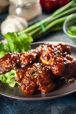 Sweet and spicy chicken wings on a plateの写真素材