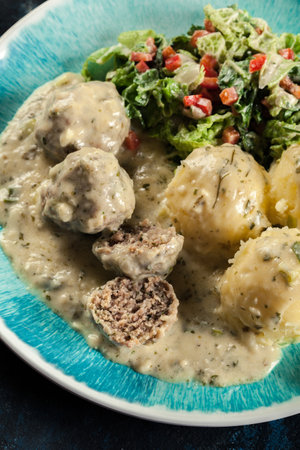 Meatballs with creamy and cheese gravy served with mashed potatoes balls and saladの写真素材