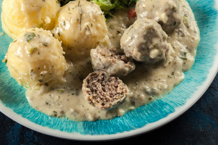 Meatballs with creamy and cheese gravy served with mashed potatoes balls and saladの写真素材