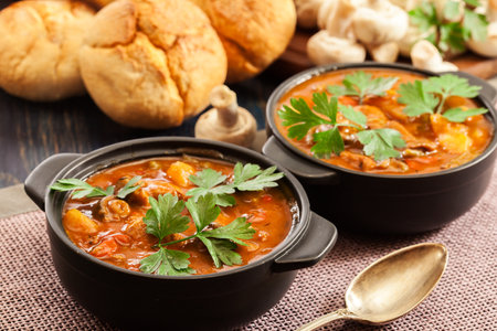 Stew soup with meat, potatoes, mushrooms and red pepper in bowlの写真素材
